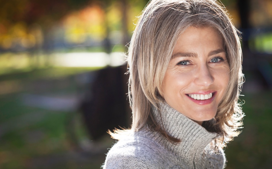 Woman with shoulder-length sandy hair and blue eyes smiling