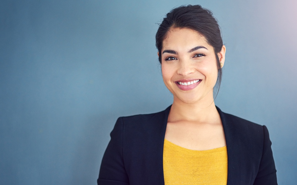 Young professional woman in a blazer and yellow sweater